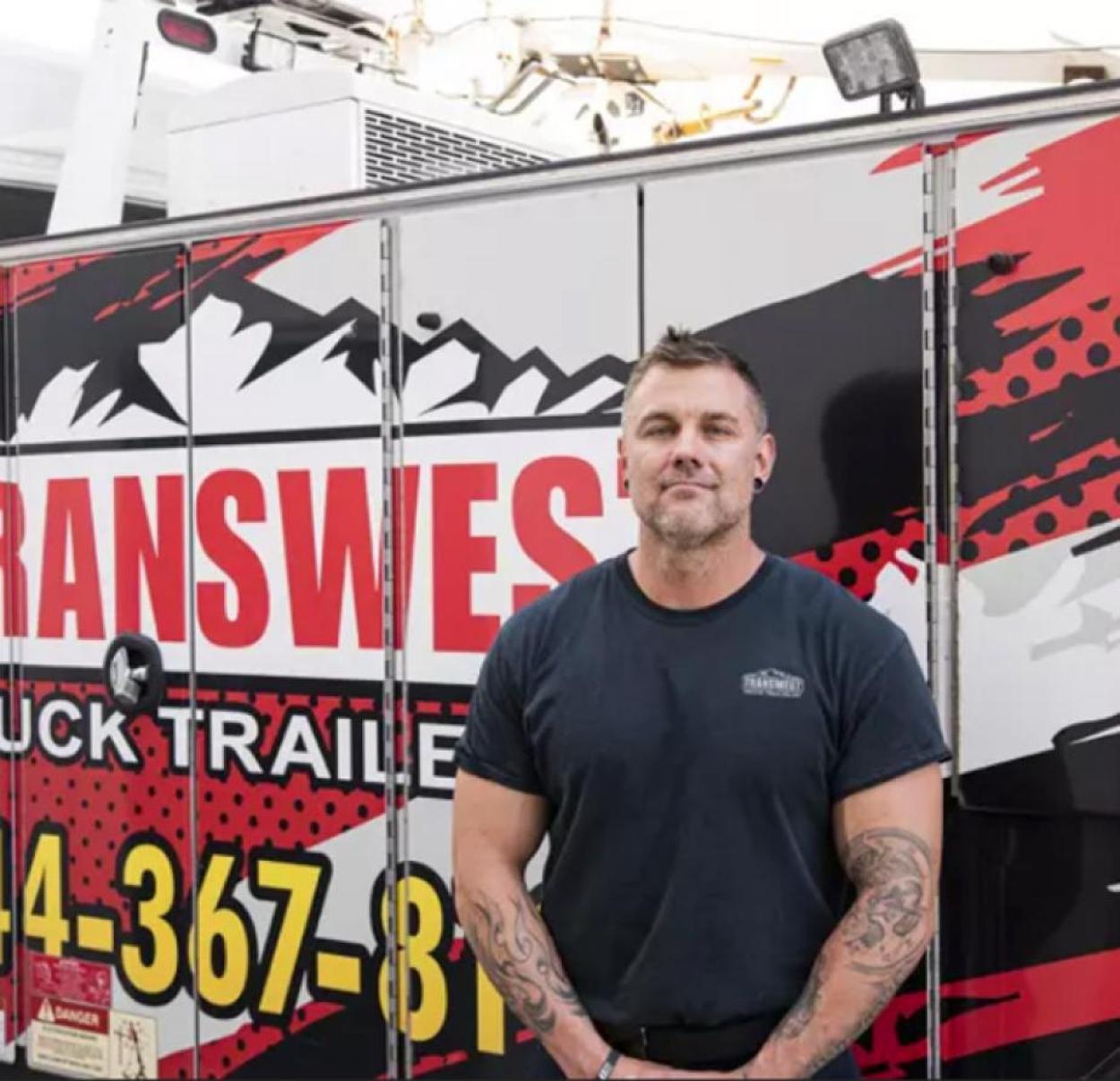 Diesel Technician standing in front of Transwest sign