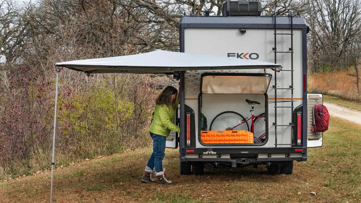 Woman loading gear in the back of a Winnebago Ekko campervan