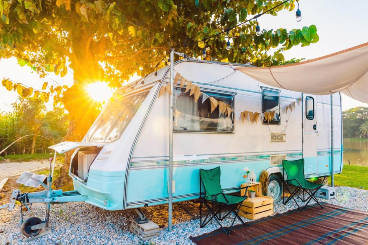 Camper in front of a tree