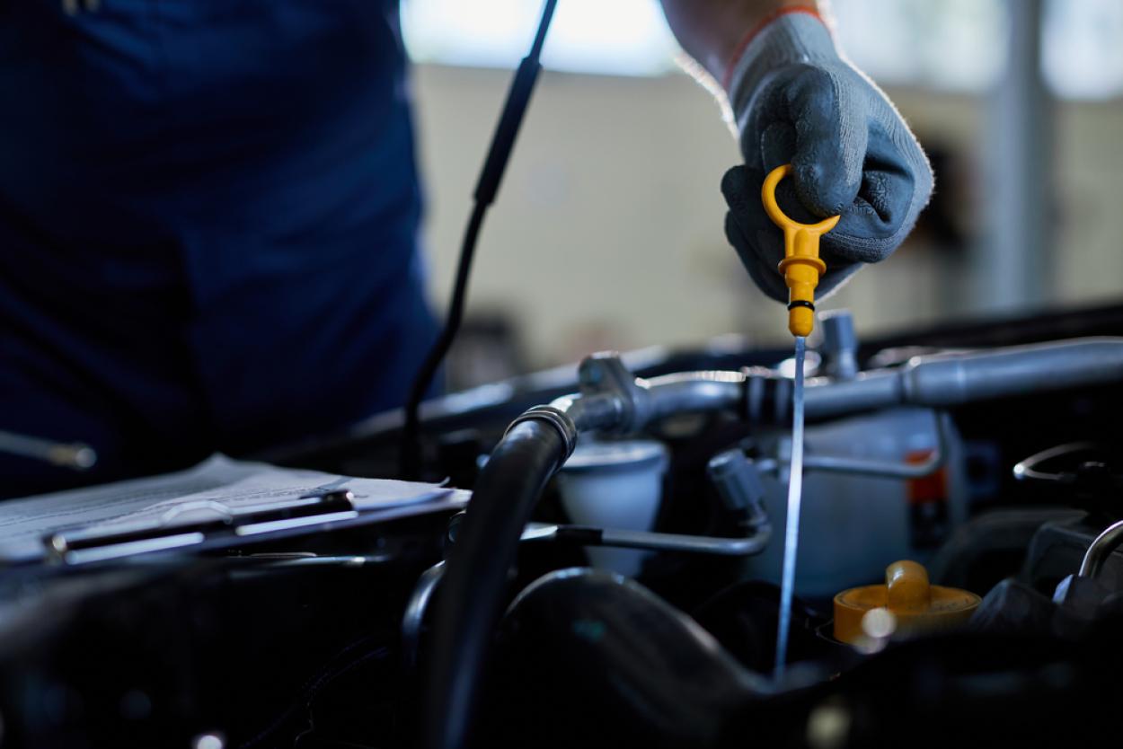 Close up of mechanic checking oil