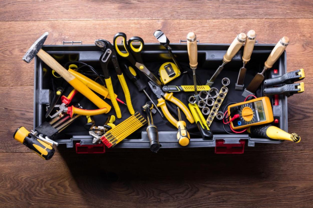 Open black plastic toolkit with tools