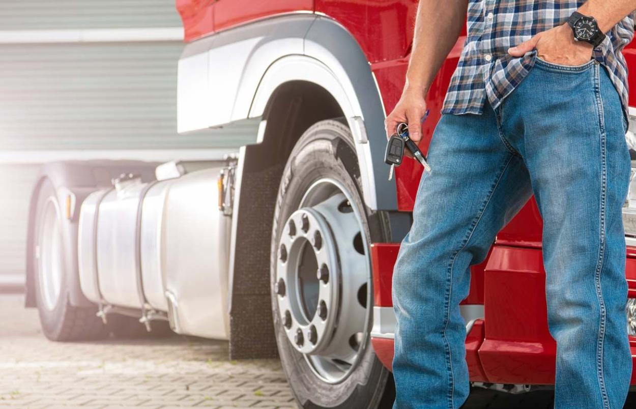 Man standing with keys in front of a commercial truck