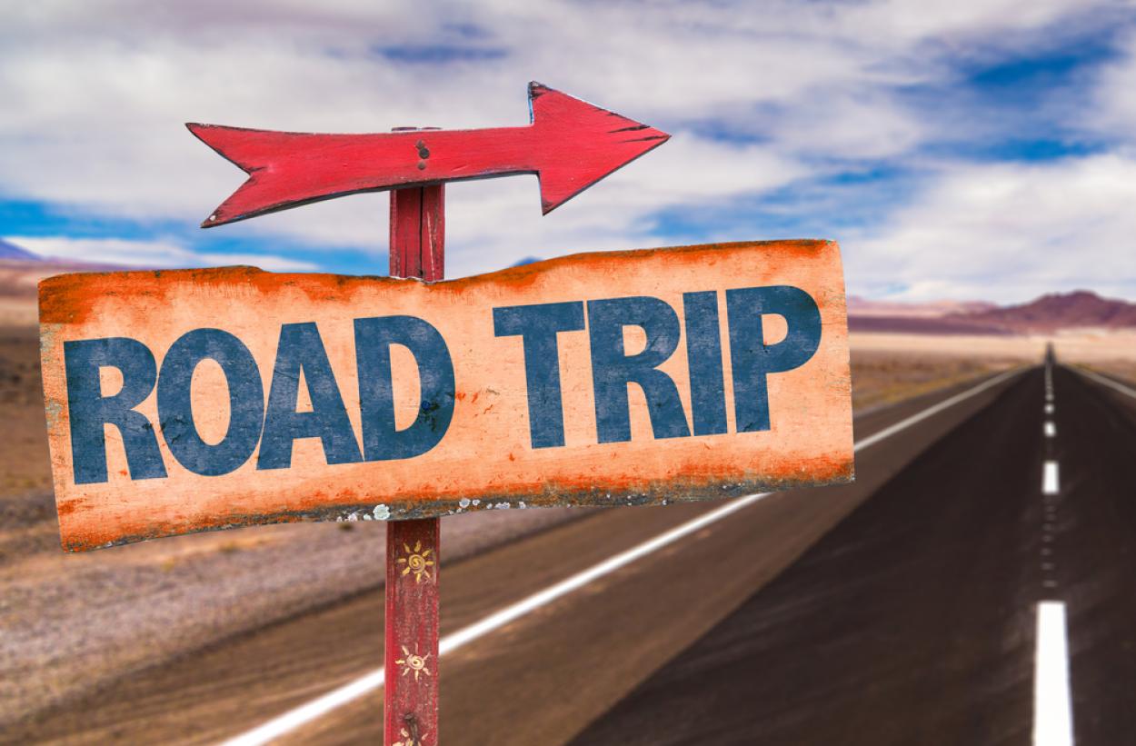 Sign reading "road trip" on a desert highway