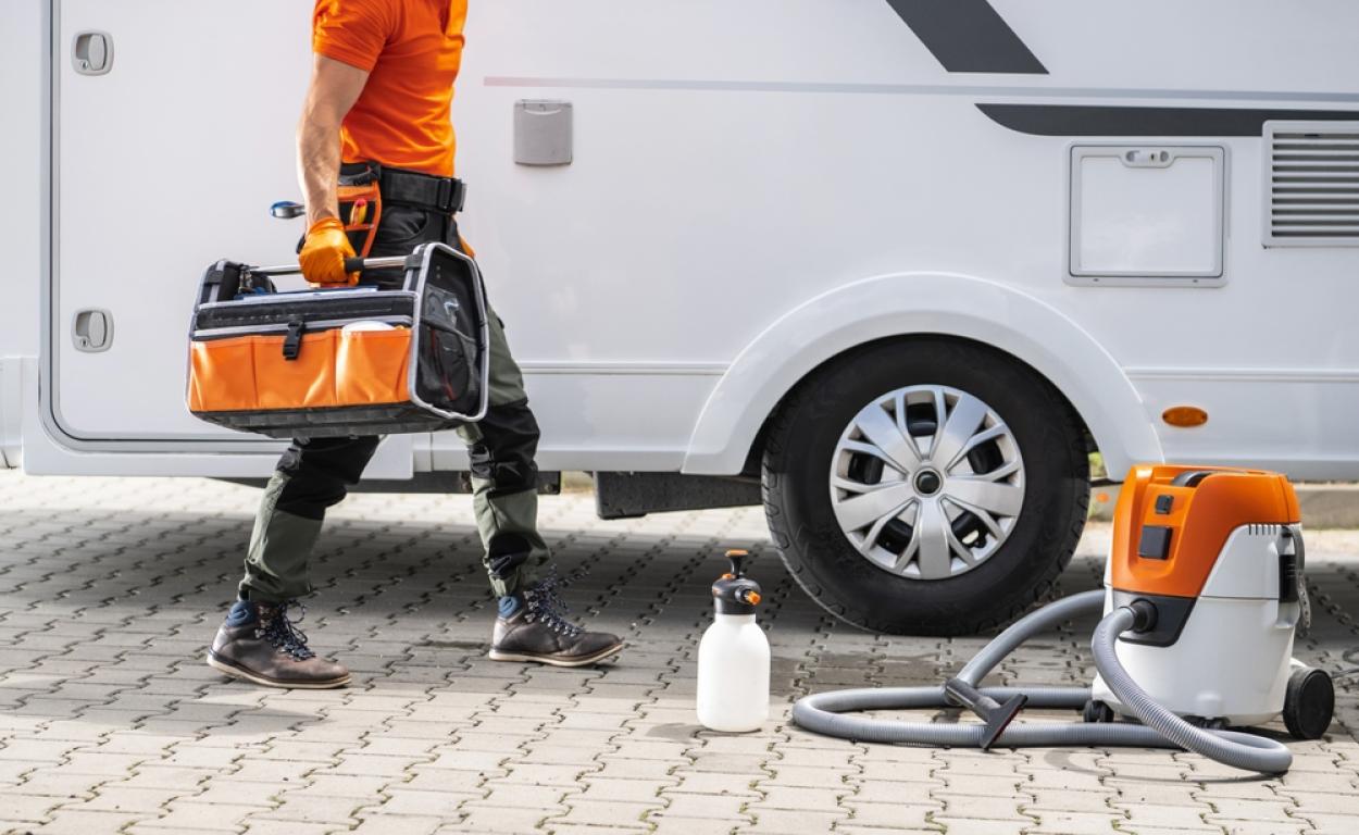 RV owner carries a full toolbox in front of an RV