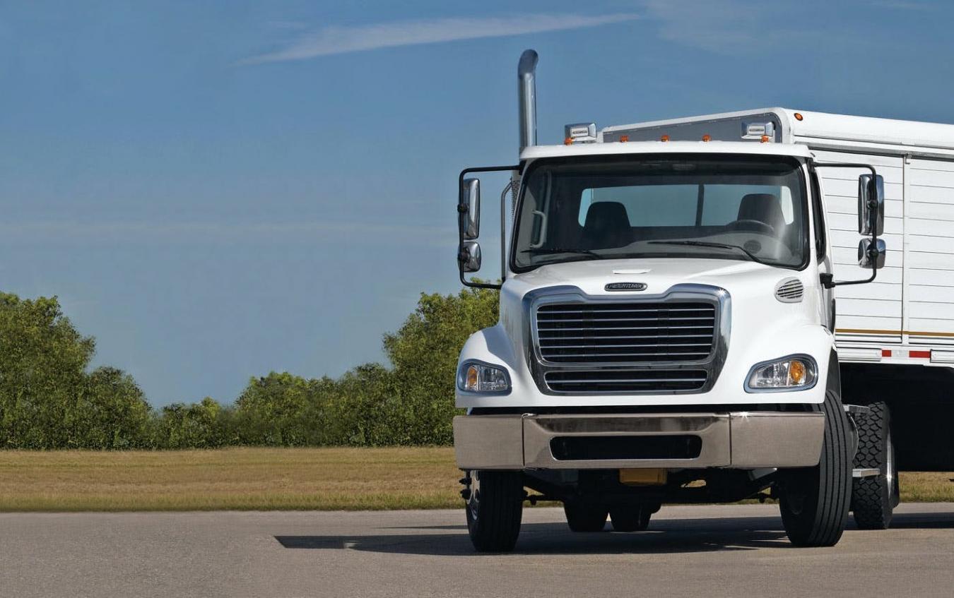 White Freightliner truck in a parking lot